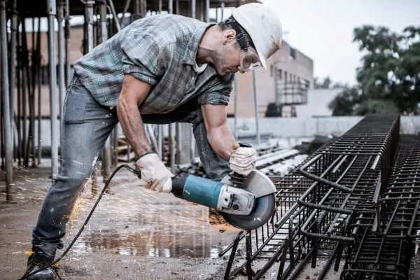 Steel reinforcement being cut to length with a grinder on site