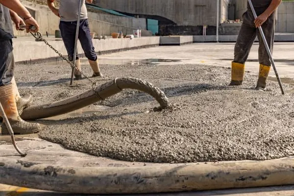 Concrete being placed by pump hose across mesh on a large pour